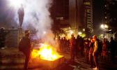 In this July 4, 2020, file photo, protesters gather near a fire in downtown Portland, Ore
