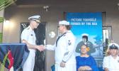 Rear Adm. Richard Meyer gives coin to Navy Counselor 1st Class Alesana Faanofoilefagaoalii