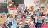 1st grade students and teachers with their new books and posters