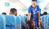 Samoa Airways flight attendant talking with a child on the airplace while another passenger looks on.