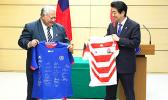 Samoa Prime Minister Tuilaepa Sailele MalielegaoiJapanese and Japan counterpart Shinzo Abe exchange jerseys