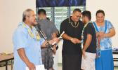 A senior player of the Samoana High School football team shaking hands with the team’s head coach Pati Pati Jr last Friday when the Booster Club donated the new uniform to the school football team. [photo AF]