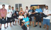 A member of the Booster Club, Flo Maiava (middle) and some seniors from the Samoana High School football team posing with their bags that contained their new football uniform, supplies and an envelope with a monetary gift — all donated by the school Booster Club last Friday. Seniors football players received a gift of $50 each, while those players in Level 11 & 10 received a gift of $30 each. [photo AF]