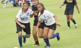 Two Samoana players defend against a Fa’asao-Marist opponent 