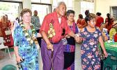 Evelyn Lili’o Satele (left) helps escort an elderly member of the community