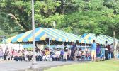 Crowds of people waiting under tents at TBAS to cash their stimulus checks