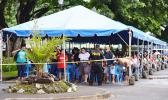 Large crowd under tents in the parking lot of the Territorial Bank of American Samoa