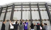 In this July 14, 2013, file photo, pastors and others raise their arms on the San Diego side of a border fence during a cross-border Sunday religious service with others on the Tijuana, Mexico side of the fence. The AP reported Sept. 8, 2017, that a story claiming Congress had approved President Donald Trump's request for $1.6 billion in border wall funding is false. (AP Photo/ Gregory Bull, File) In this July 14, 2013, file photo, pastors and others raise their arms on the San Diego side of a border fence during a cross-border Sunday religious service with others on the Tijuana, Mexico side of the fence. The AP reported Sept. 8, 2017, that a story claiming Congress had approved President Donald Trump's request for $1.6 billion in border wall funding is false. (AP Photo/ Gregory Bull, File)