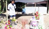 Tu'ivale Luamanuvae beside the graves of his three children