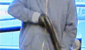Totoe Opeti Sakaria, Jr., who is masked, wearing sunglasses and holding a shotgun