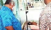 Prime Minister Tuilaepa Sailele Malielegaoi in a mask with sick child