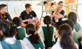 Seaman Eli Teagle, Ensign Landon Klopfenstien, and Ensign Cecelia Hosley read to students at LufiLufi Primary School 