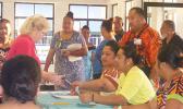 A registered voter (left) speaking to election officials seconds after the polling station at Ili’ili opened at 6a.m. today.  [photo: Fili Sagapolutele]
