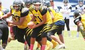 Daniel Fano of Nu’uuli, looking to send one of his backers on a running play, in the opening half of their Varsity match against the Warriors.  [photo: TG]