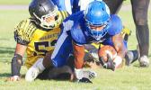 Moe Faleali’i of Samoana brought down immediately by Junior Linebacker, Branson Pualau of Nu’uuli during the second quarter of the Varsity showdown last Friday evening.  [photo: TG]