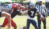 Samoana Sharks quarterback Viliamu Tanielu trying to hold off a vicious blitz by Ronnie Oa of