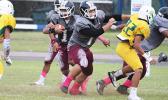 Warriors offensive lineman Marvin Atuatasi opening a huge gap for Panapa Filoiali’i at midfield, during the opening half of their varsity match against the Lions last Friday evening – Tafuna shut out Leone and claimed victory in their 38 point win.  [photo: TG]