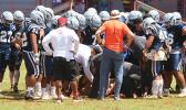 Samoana Sharks varsity squad huddling around one of their injured players