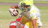 A Leone Lions running back is dragged down in the backfield by a Viking defender
