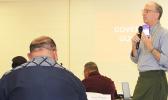 ASTCA CEO Wolman holds up for cabinet members one of the new ASTCA mobile phones