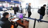 Staff members take passengers' body temperature at Tianhe International Airport in Wuhan