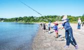 Janet Coit casts her line into the water with others in background